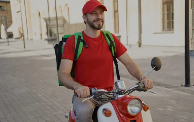 Repartidor sonriente en moto con su mochila de entregas